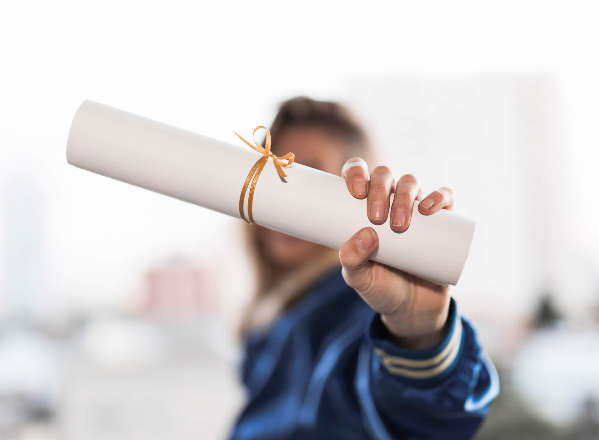 woman holds her degree